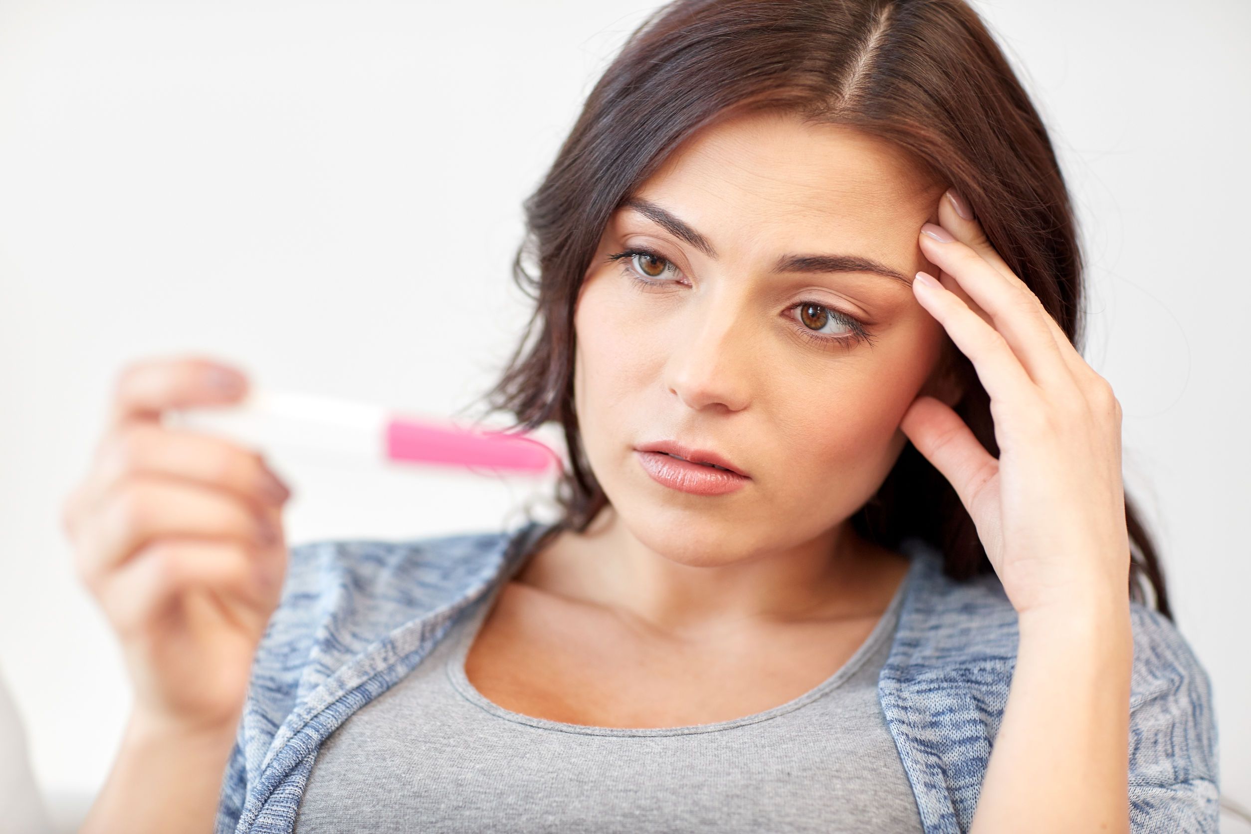sad woman looking at home pregnancy test